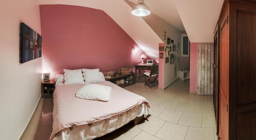 A room at Ti Coin Tranquille in Saint-Leu: double bed, pink walls and a small desk