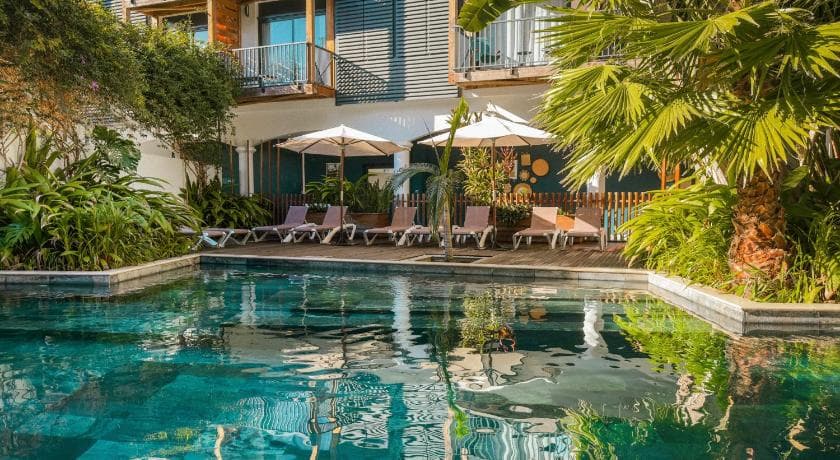 The pool at Santa Apolonia in Saint-Leu, with sunloungers and parasols below the balconies