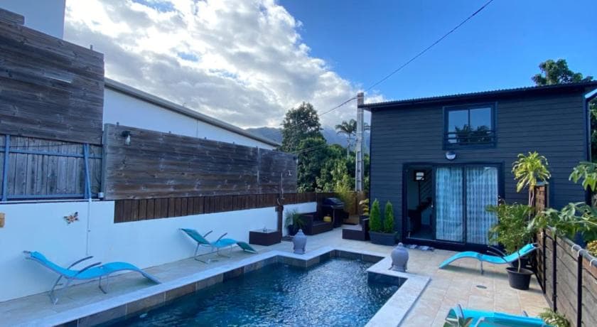 The dark-clad Le Corossol bungalow, a sun lounger and the private pool beside the terrace
