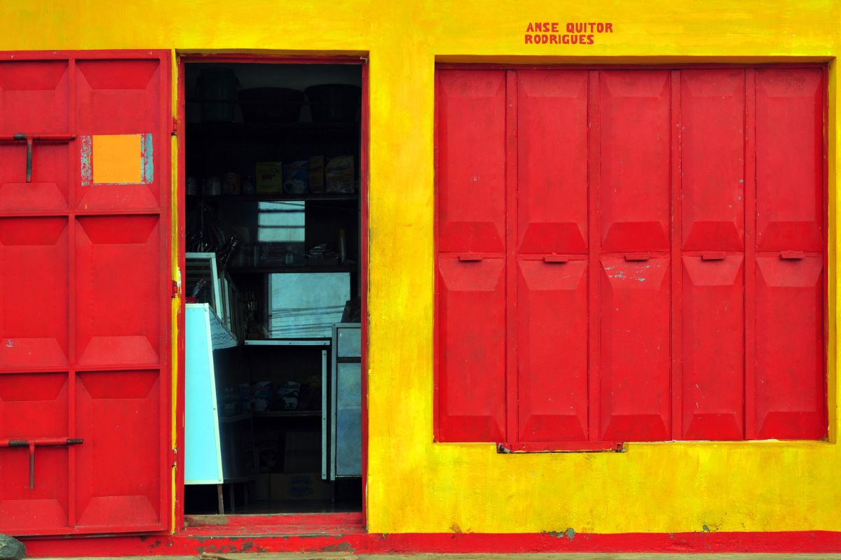 Façade colorée jaune et rouge d'une boutique à Anse Quitor Rodrigues, architecture créole vernaculaire