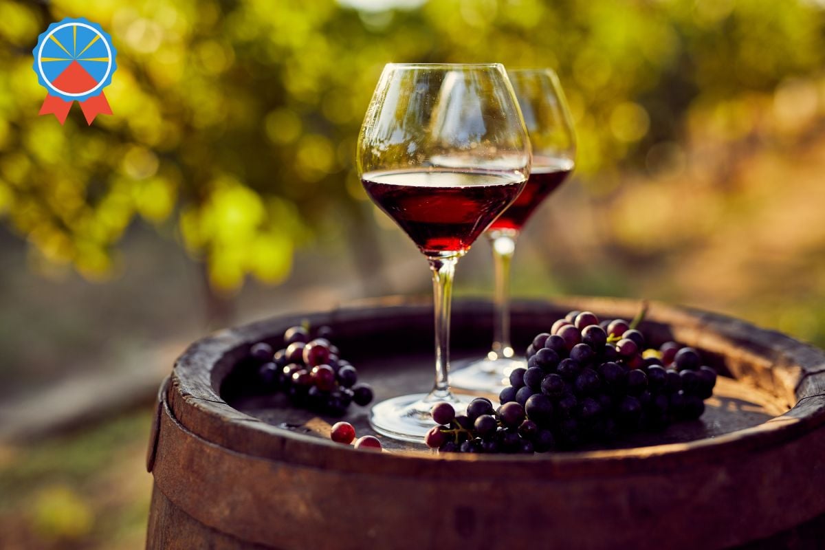 Verres de vin rouge sur un tonneau dans des vignes