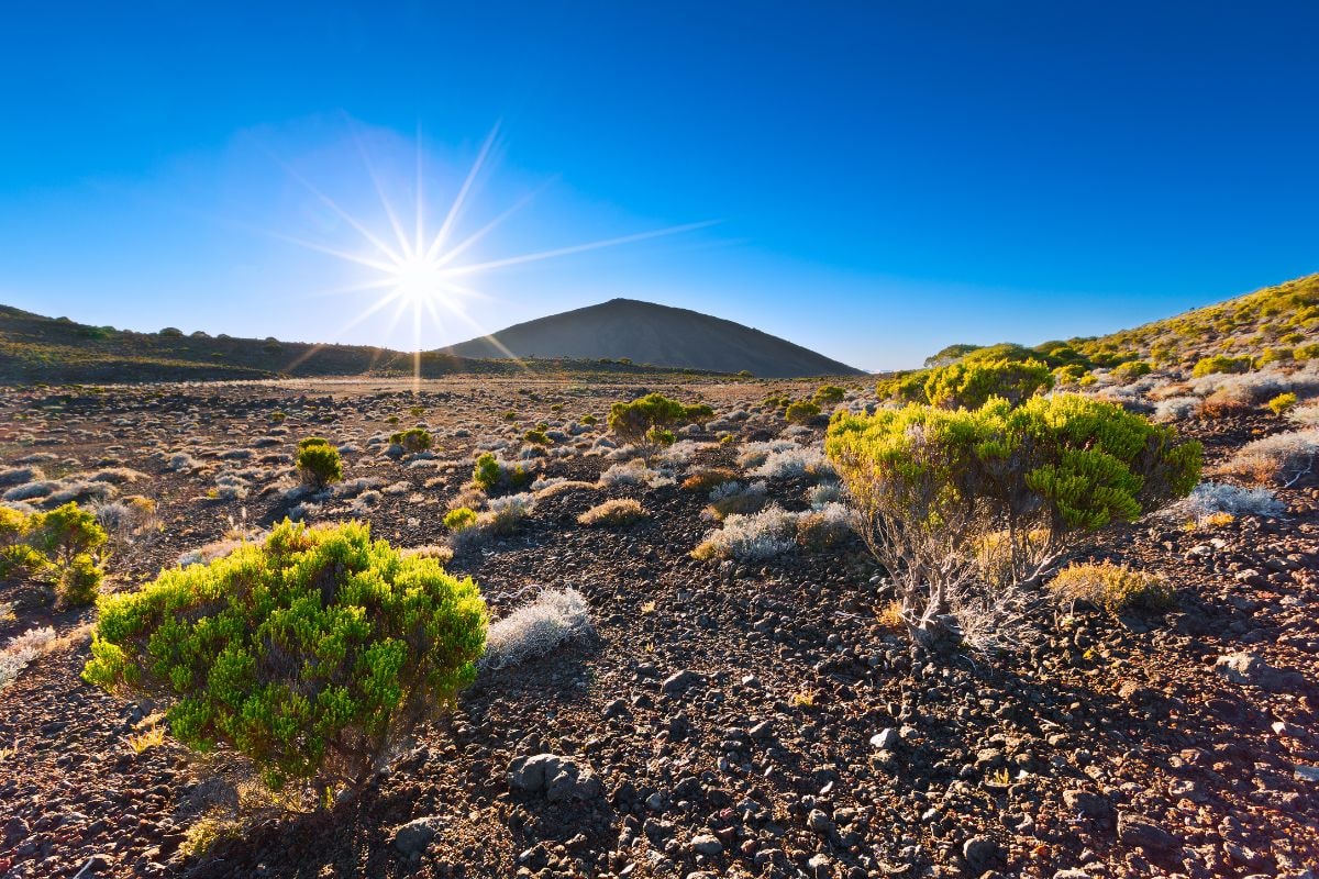 Soleil rasant sur la Plaine des Sables à La Réunion, paysage minéral rouge
