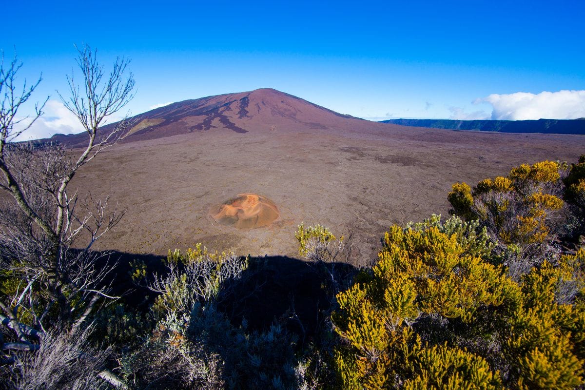 Cratère Formica Leo sur les pentes du Piton de la Fournaise à La Réunion, paysage minéral noir et orange, ciel bleu profond