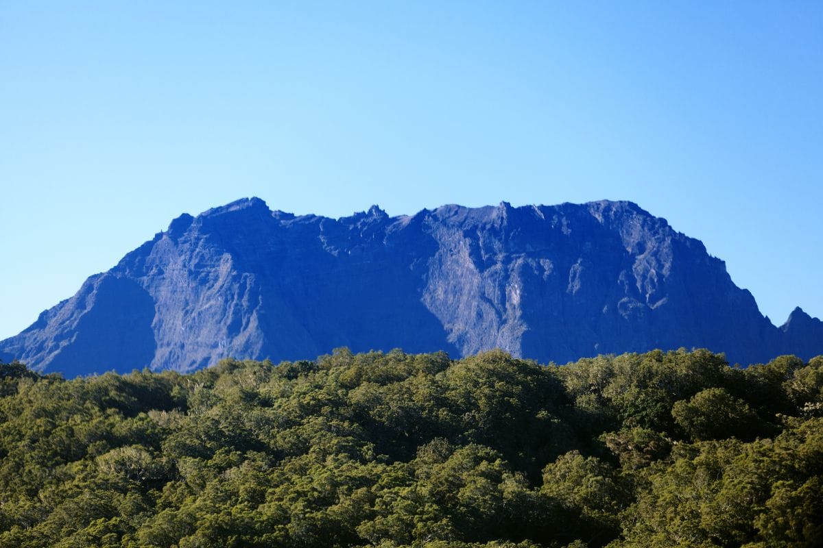 Massif du Piton des Neiges à La Réunion vu depuis Cilaos, sommet rocheux émergeant de la mer de nuages au lever du soleil