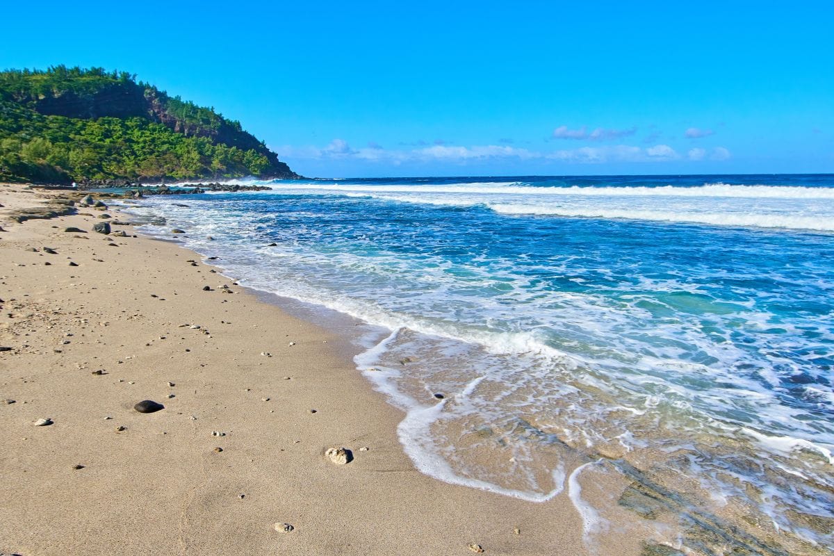 Plage de Saint-Leu à La Réunion avec sable clair, rocher volcanique et océan turquoise