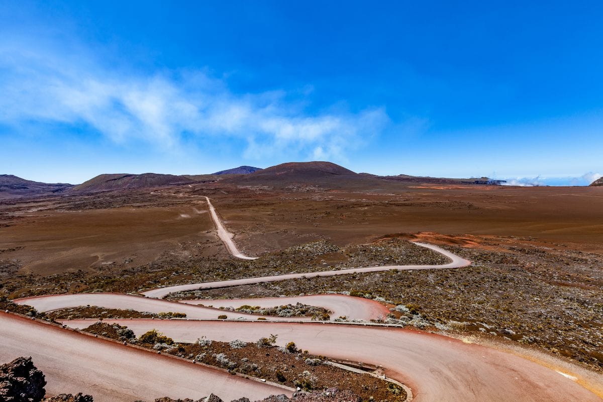 Piste cahoteuse traversant la Plaine des Sables à La Réunion, paysage minéral désertique vers le volcan