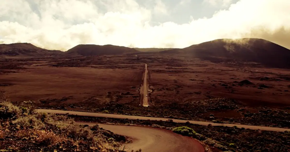Famille randonnant sur la Plaine des Sables au Piton de la Fournaise, paysage volcanique orangé