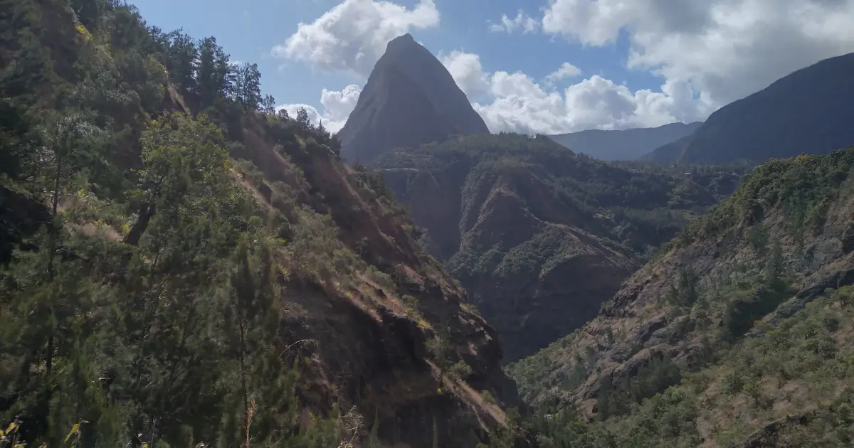 Piton de la Réunion vu depuis un sentier de Mafate, ciel bleu et végétation tropicale