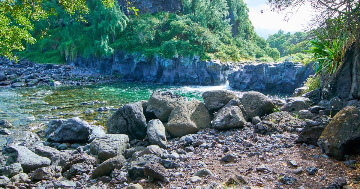 Bassin tranquille avec galets en bordure de rivière Langevin pour la baignade