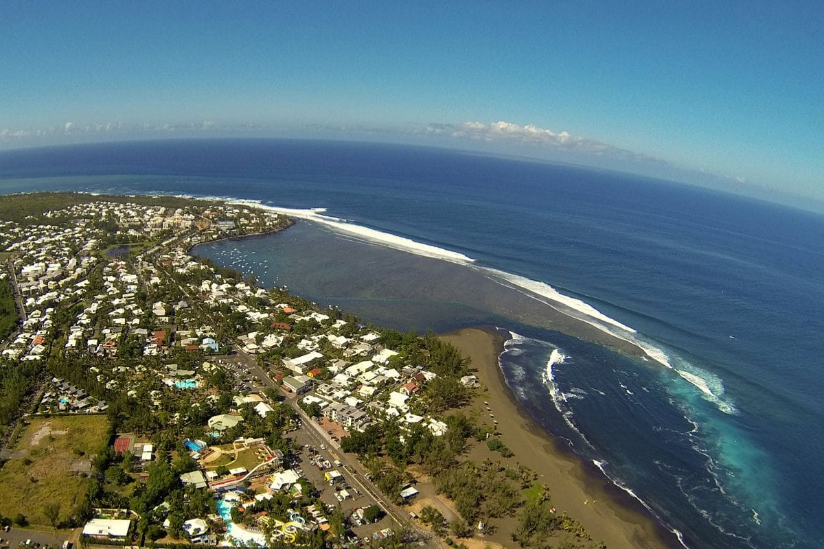 Plage de sable noir de l'Étang-Salé à La Réunion avec forêt de filaos en arrière-plan