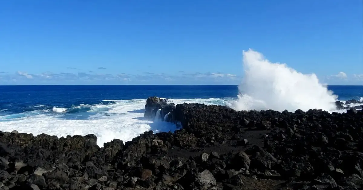 The Gouffre at L'Étang-Salé, a wave throwing a plume of spray over the basalt rocks
