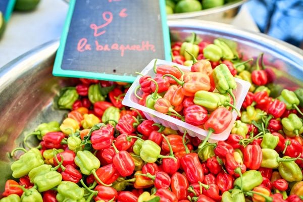 Bassine de piments cabri rouges, verts et oranges sur le marché forain de Saint-Pierre avec étiquette « la barquette »