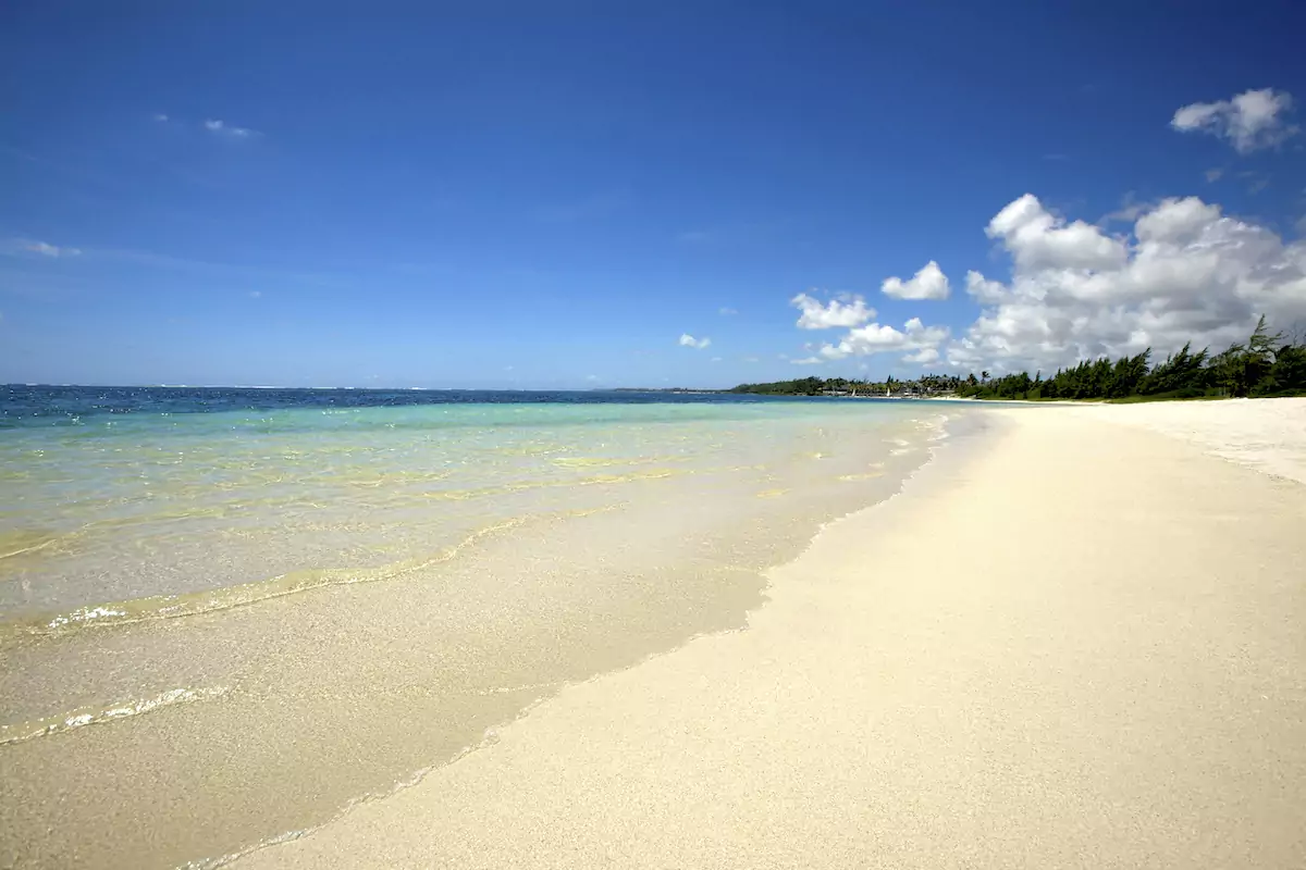 Plage de sable blanc et lagon cristallin bordés de palmiers, île Maurice