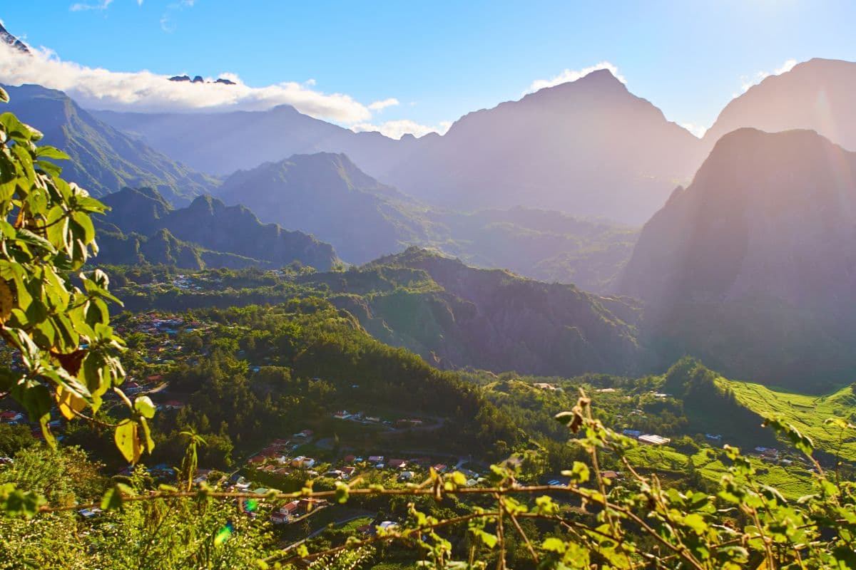 Village niché au fond d'un cirque verdoyant de La Réunion au soleil, remparts et habitations éparses dans les Hauts