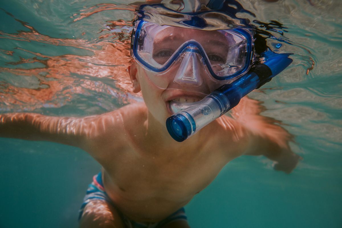 A child snorkelling with mask and snorkel in Reunion Island's turquoise lagoon