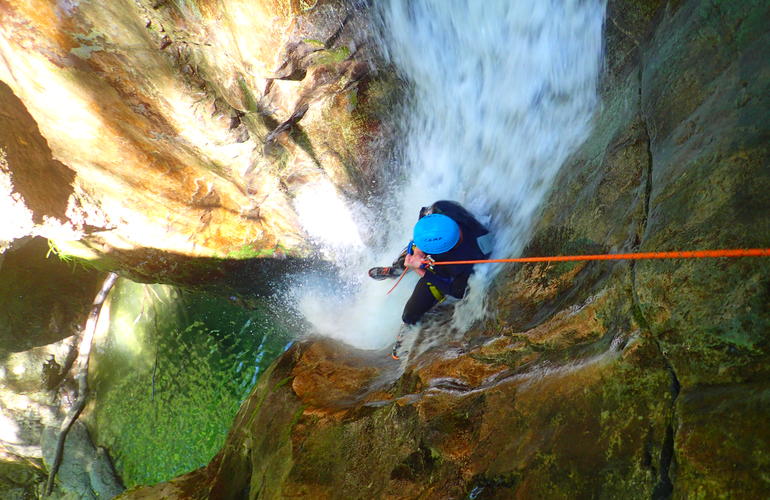 Personne flottant en combinaison dans une vasque ardéchoise au cœur d'un canyon