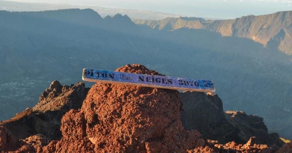 Plaque sommet Piton des Neiges 3070 mètres avec vue sur les remparts au lever du soleil