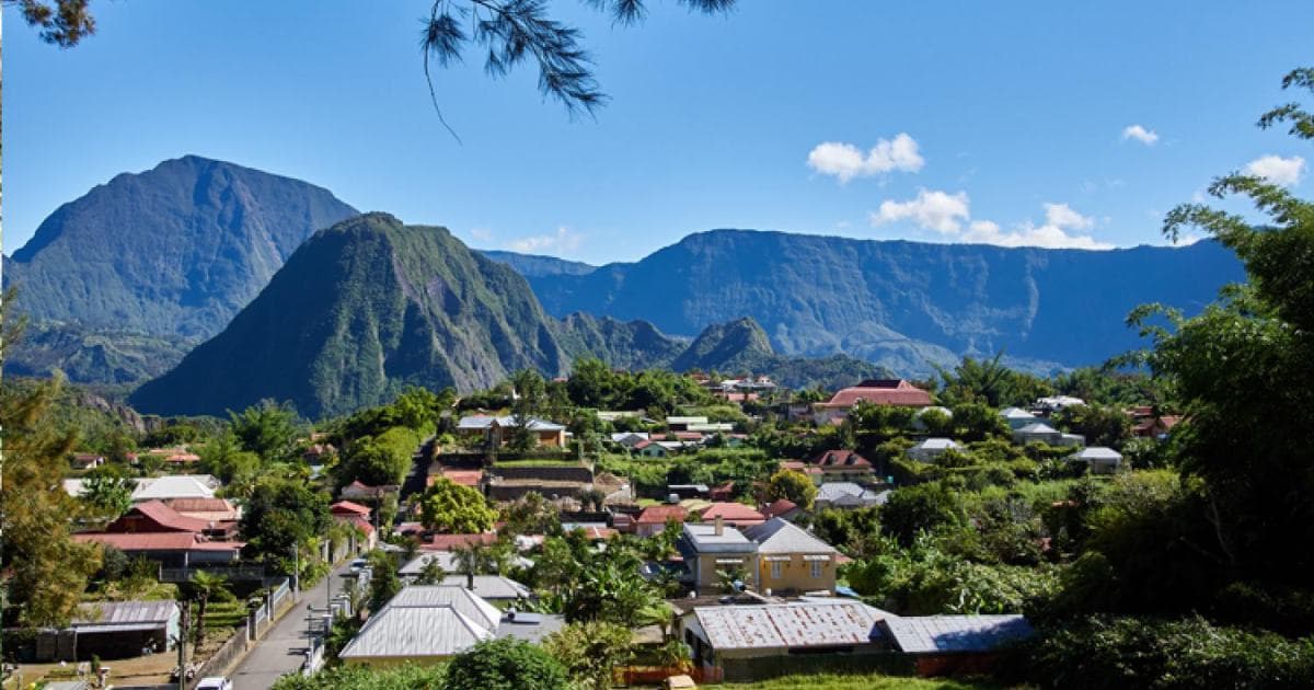 Hell-Bourg rooftops among the greenery, with Piton d'Anchaing and the Salazie cirque walls behind