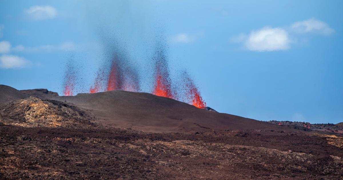 An eruption of Piton de la Fournaise in Reunion Island in December, active lava fountains under a blue austral-summer sky