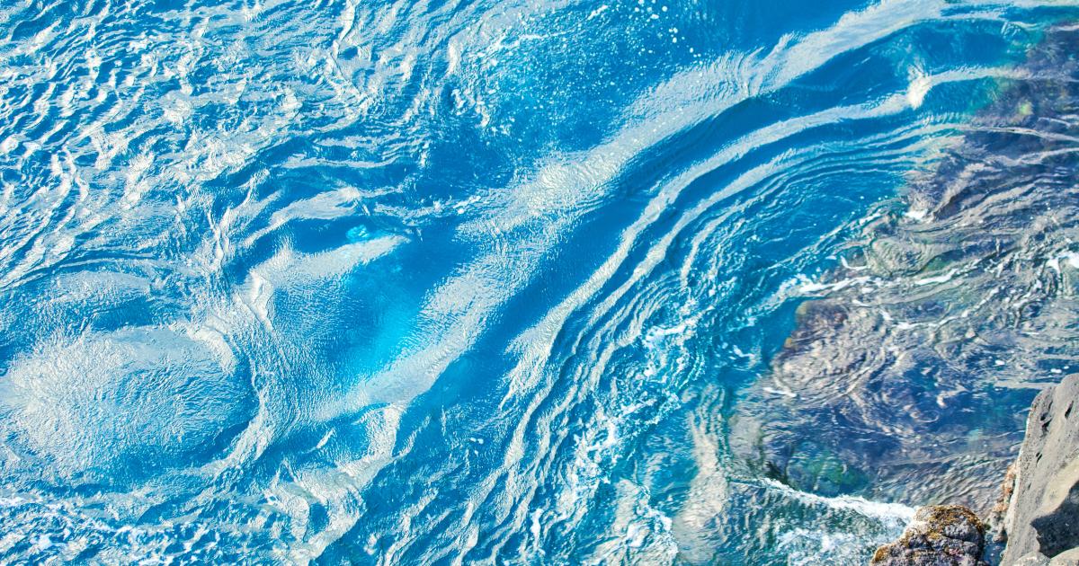 Turquoise waves foaming over a basalt coastline in Reunion Island in October, the sea warming up under a clear end-of-dry-season sky