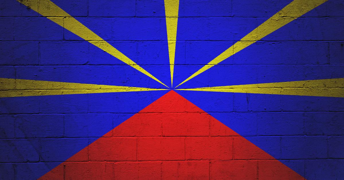 Drapeau de La Réunion peint sur un mur de briques, identité culturelle créole au cœur de l'hiver austral