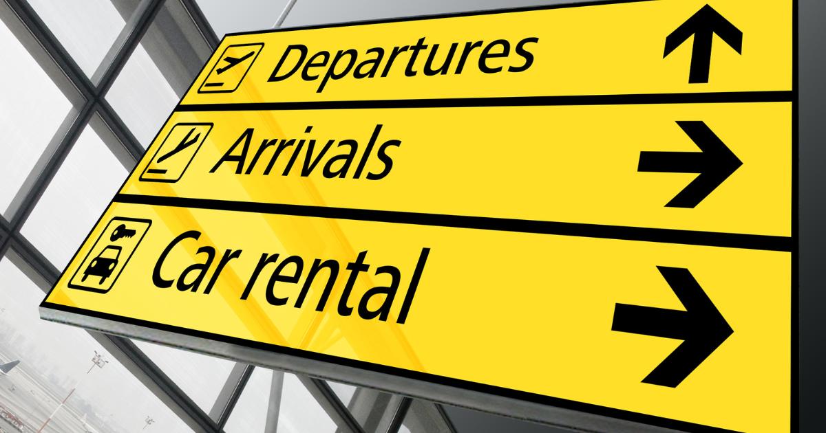 Panneaux jaunes Departures Arrivals Car rental suspendus dans un hall d'aéroport