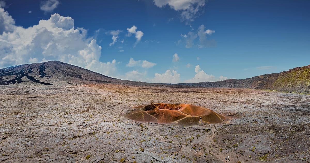 Vue panoramique sur le Piton de la Fournaise et la plaine des Sables sous un ciel bleu, sentier praticable en avril