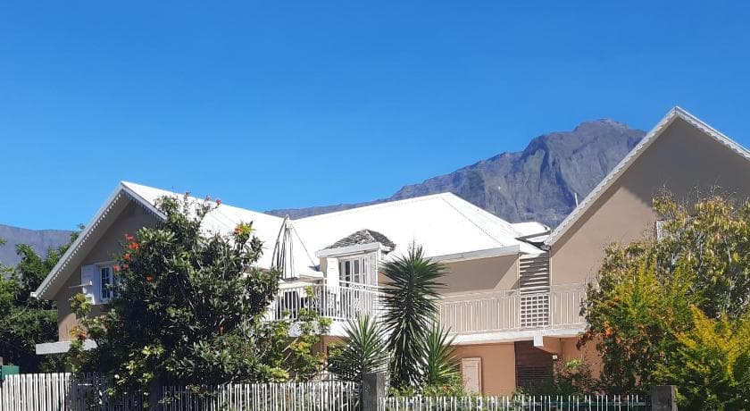 Le Calou Pilon in Cilaos: pale walls and white roofs with a cirque peak behind
