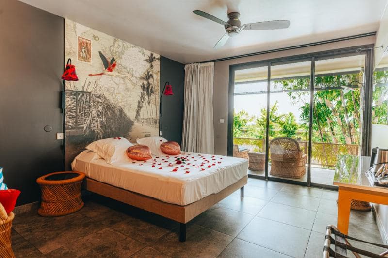 A room at Dina Morgabine Saint-Gilles: bed, wall mural and a glass door onto a leafy terrace