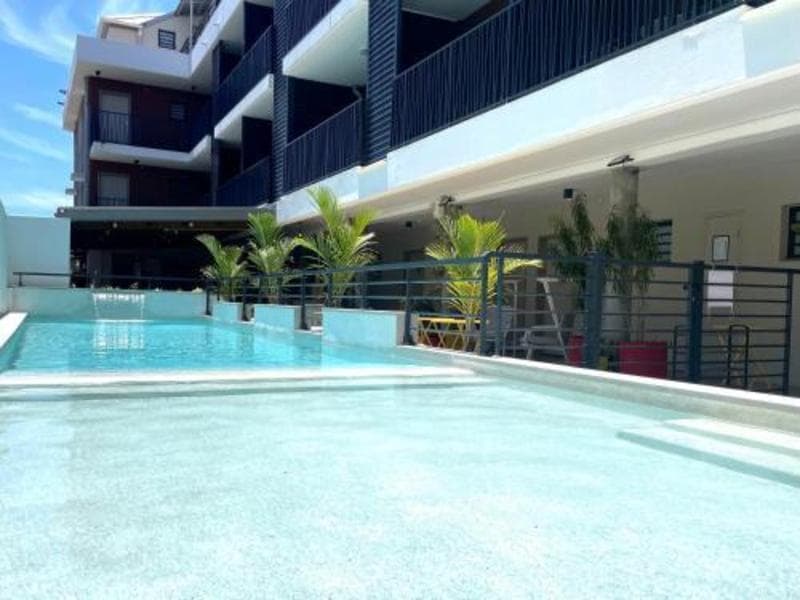 Piscine de l'Hôtel Le Terre Sainte à Saint-Pierre, bordée de plantes tropicales au pied du bâtiment