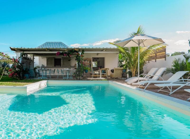 Piscine du Mandala Moris, terrasse sous pergola, transats blancs et parasol