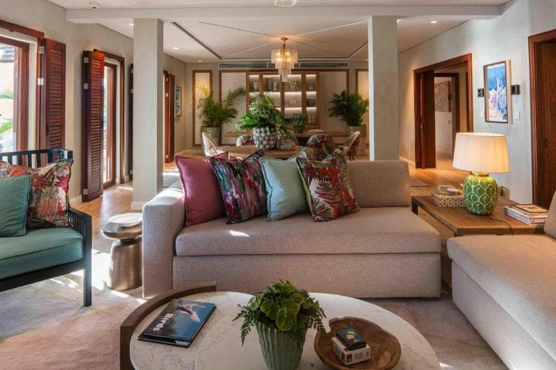Salon d'une suite du Hilton Mauritius : canapés clairs, coussins colorés, lampes et plantes vertes