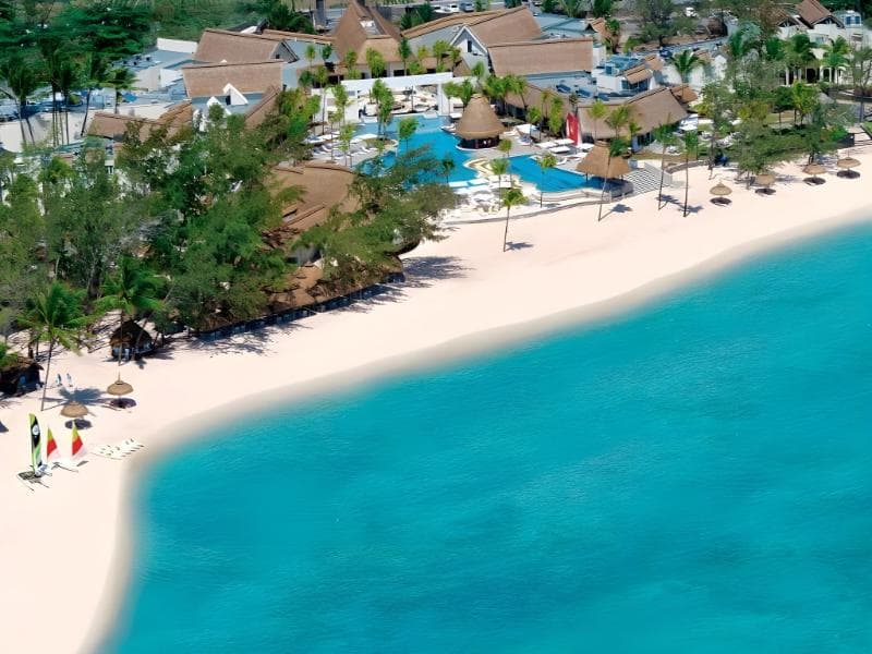 Ambre vu du ciel : longue plage de sable blanc, toits de chaume, piscines et lagon turquoise