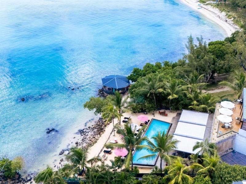 Mystik from above: an infinity pool, a kiosk on the rocks, a turquoise lagoon and the curve of Mont Choisy beach