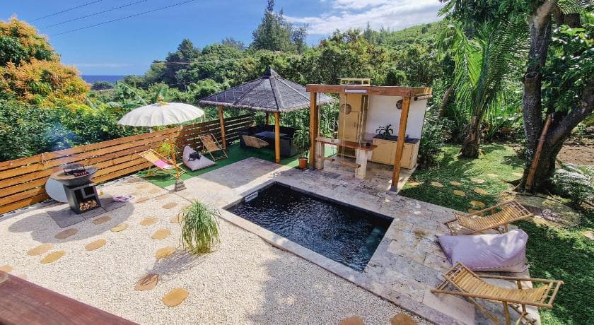 Jardin de la villa Manap'Tipik avec son bassin carré, sa paillote, ses transats et sa cuisine d'été