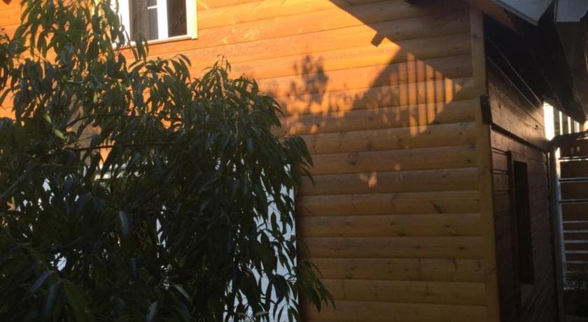 Case en bois de Cœur Créole au soleil couchant, feuillage au premier plan
