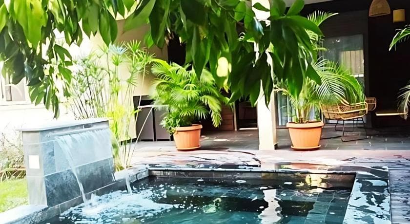 A small pool with a water feature and potted plants on the terrace of Villa Les Jardins de la Trinité