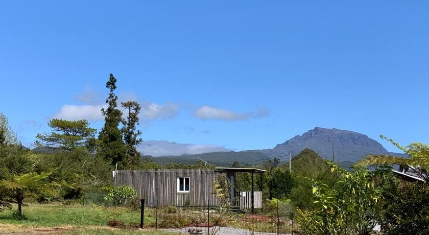 Chalet en bois des Capucines dans la verdure, un sommet au loin