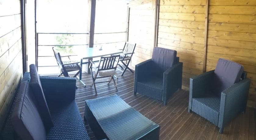 The wooden terrace of a unit at Au ti bonheur d'en O', with wicker armchairs and a table