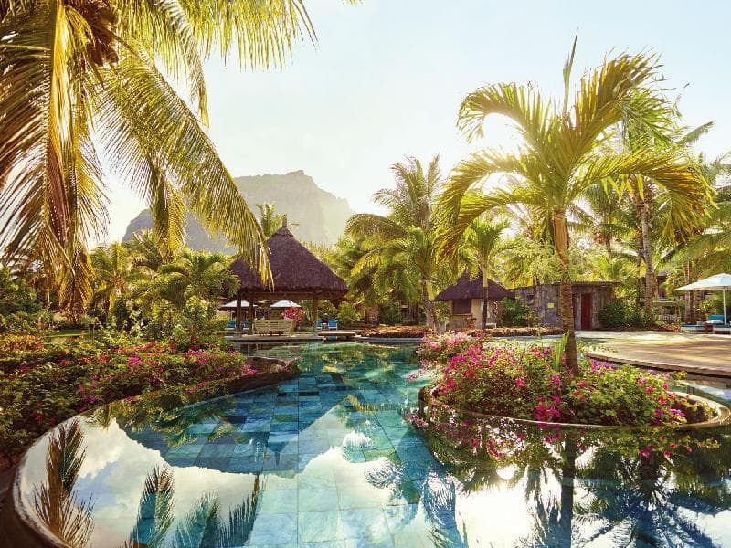 Piscine fleurie de LUX* Le Morne entre palmiers et paillotes, le Morne Brabant en arrière-plan