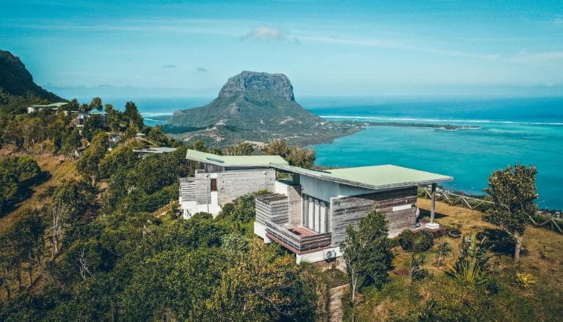 Chalets en bois des Chalets Chamarel sur la colline, le Morne Brabant et le lagon au loin