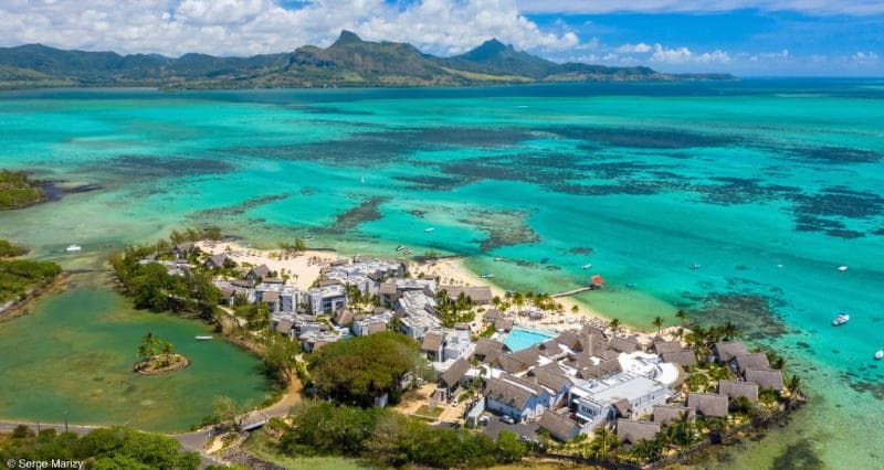 Vue aérienne du Preskil Island Resort sur sa presqu'île, lagon turquoise et montagnes au fond