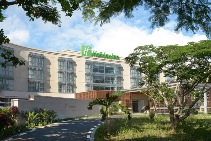 Façade moderne du Holiday Inn Mauritius Mon Trésor sous un ciel bleu