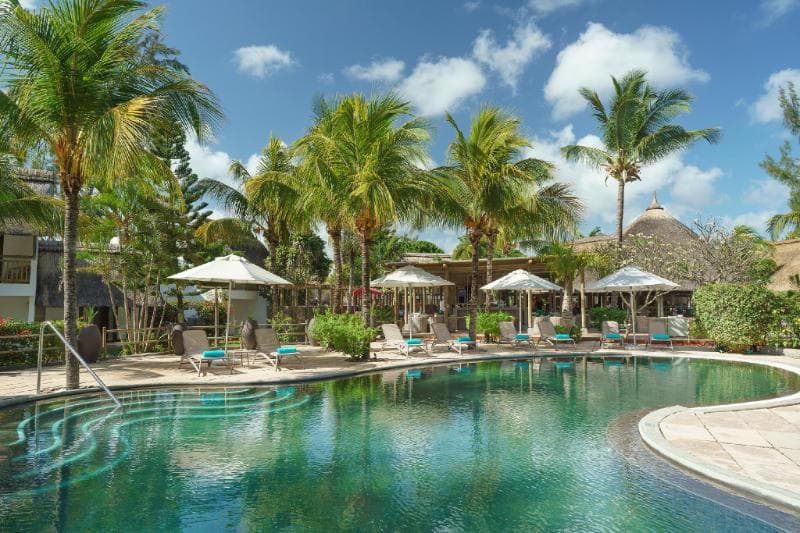 The pool at Coin de Mire Attitude, surrounded by palms, loungers and parasols