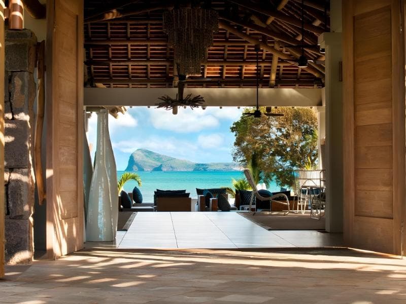 Zilwa Attitude's open-sided lobby under a wooden roof, looking out to the lagoon and an islet